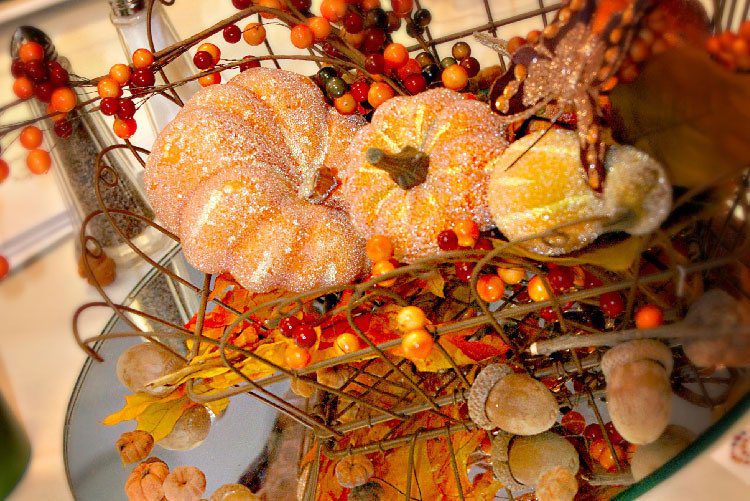 basket full of fall-themed leaves and fake pumpkin