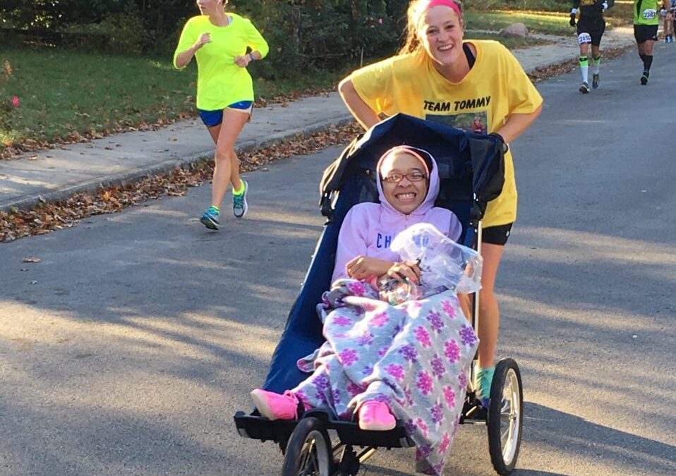 teen girl pushing girl in wheelchair during the Run, Walk, Roll event