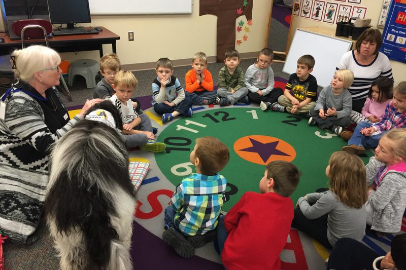 Group of elementary school students sitting in a circle listening to disability awareness lesson.