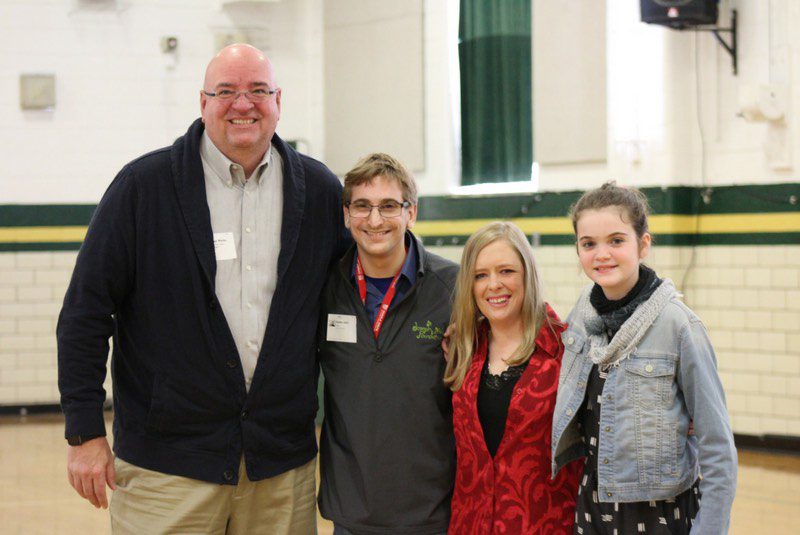 Group of four Joseph Maley Foundation volunteer speakers smiling for camera in a school gym.