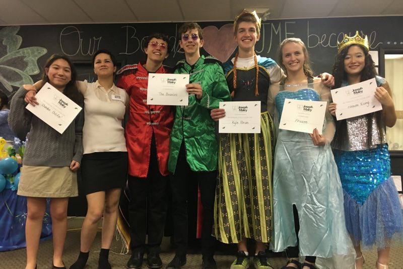 Group of teenage Joseph Maley Foundation volunteers smiling in a row holding up certificates.