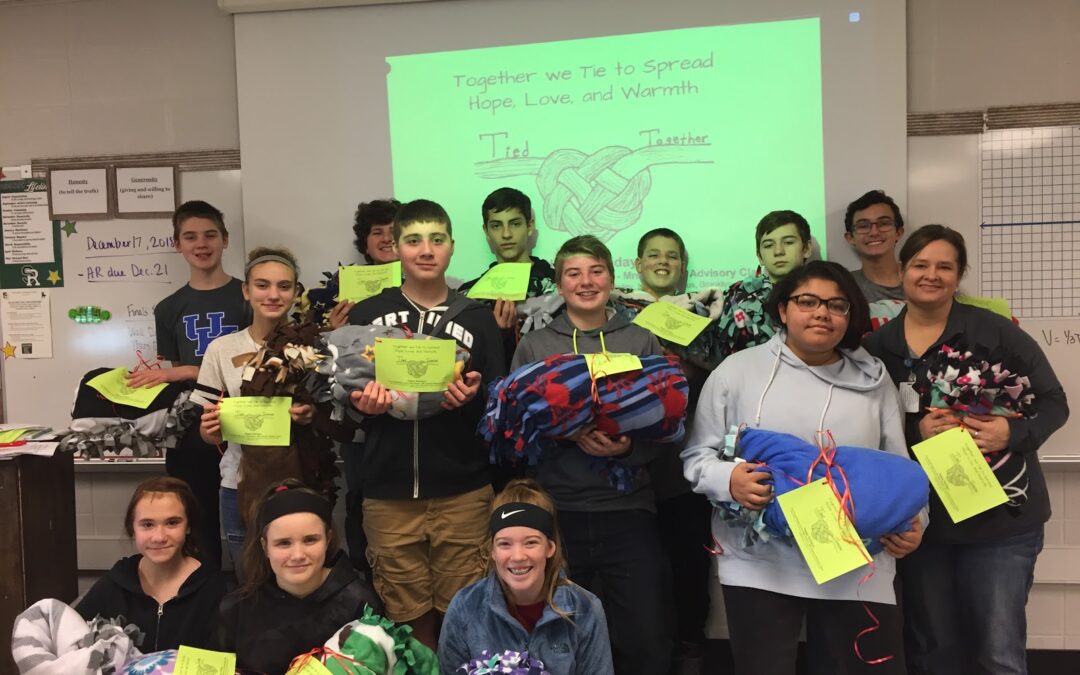 Group of middle school students in their classroom posing for a group picture.