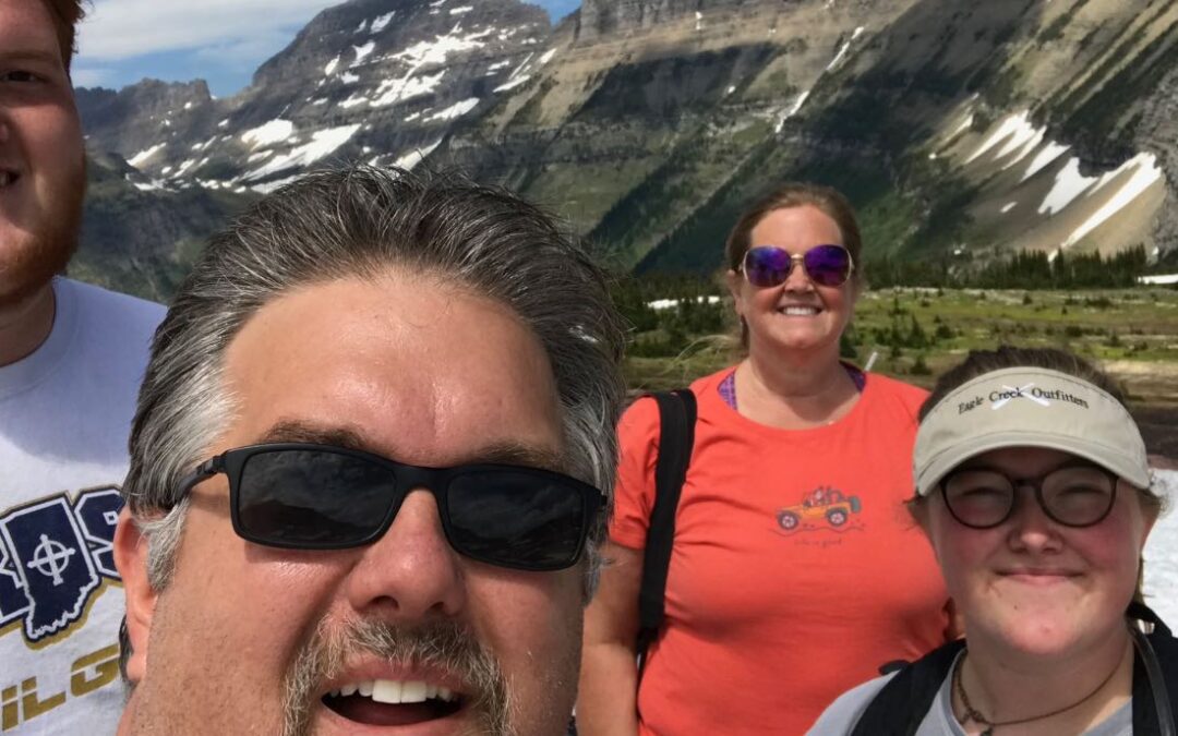 Eric Schommer with his, daughter, and son taking selfie in front of a mountain