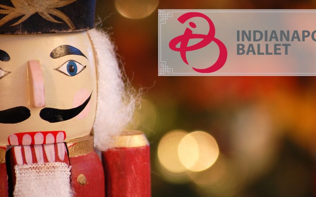Close up of the face of a nutcracker with blurry Christmas lights in the background and a banner in the right corner that reads Indianapolis Ballet