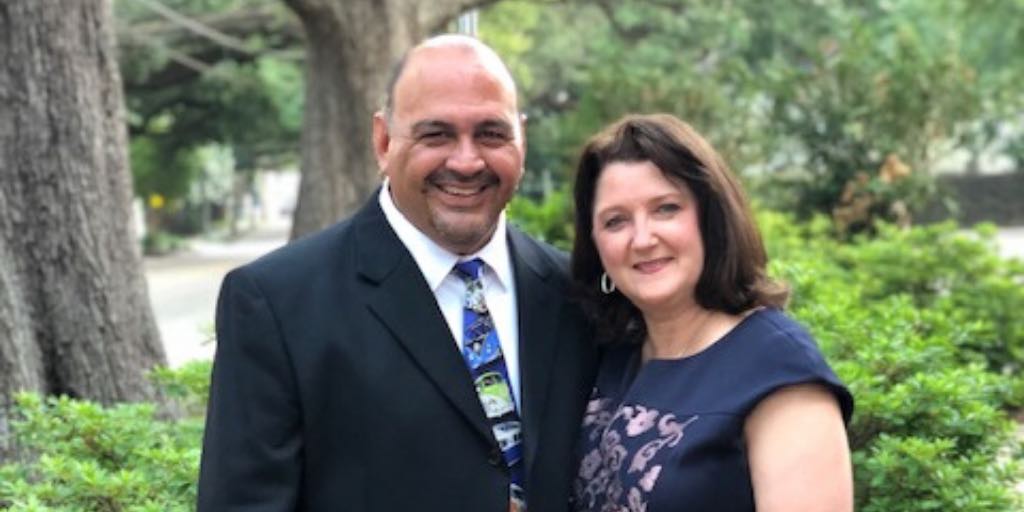 Alfie Hernandez and his wife posing together for a picture outside