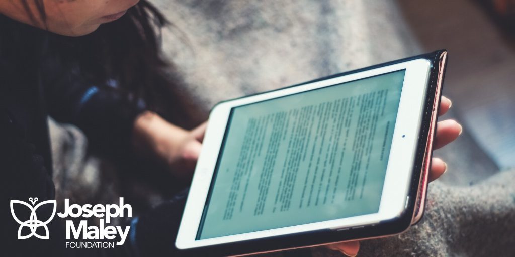 Female holding an iPad and reading an e-book